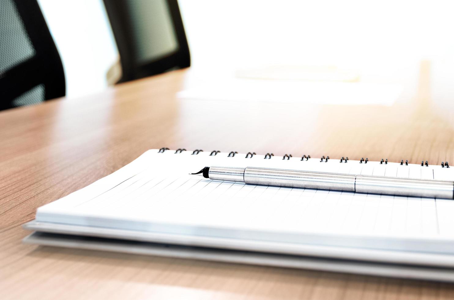 Ballpoint and notebook on table photo