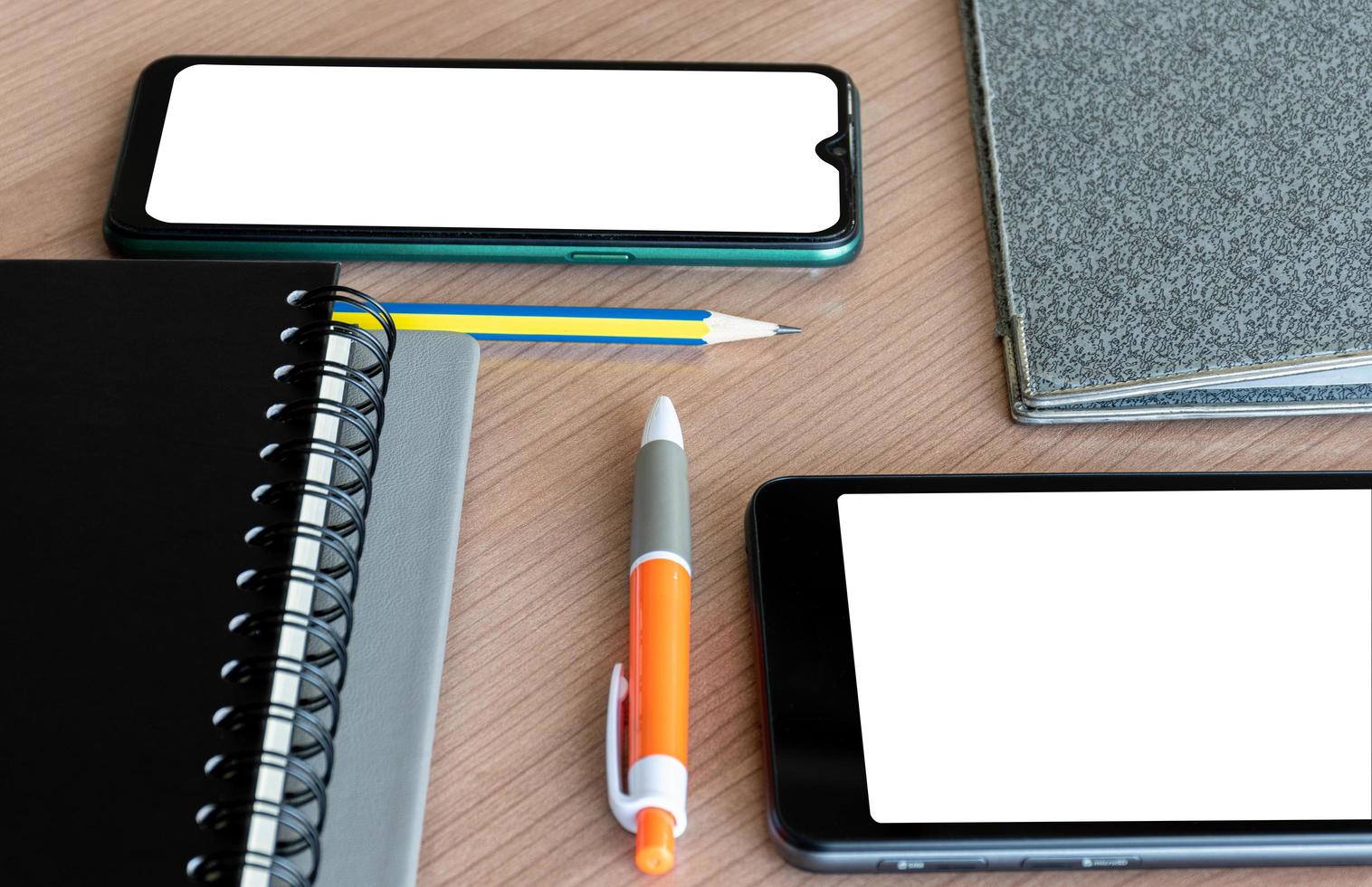 Smartphone, pen, pencil, notebook, file on table with clipping part of smartphone photo