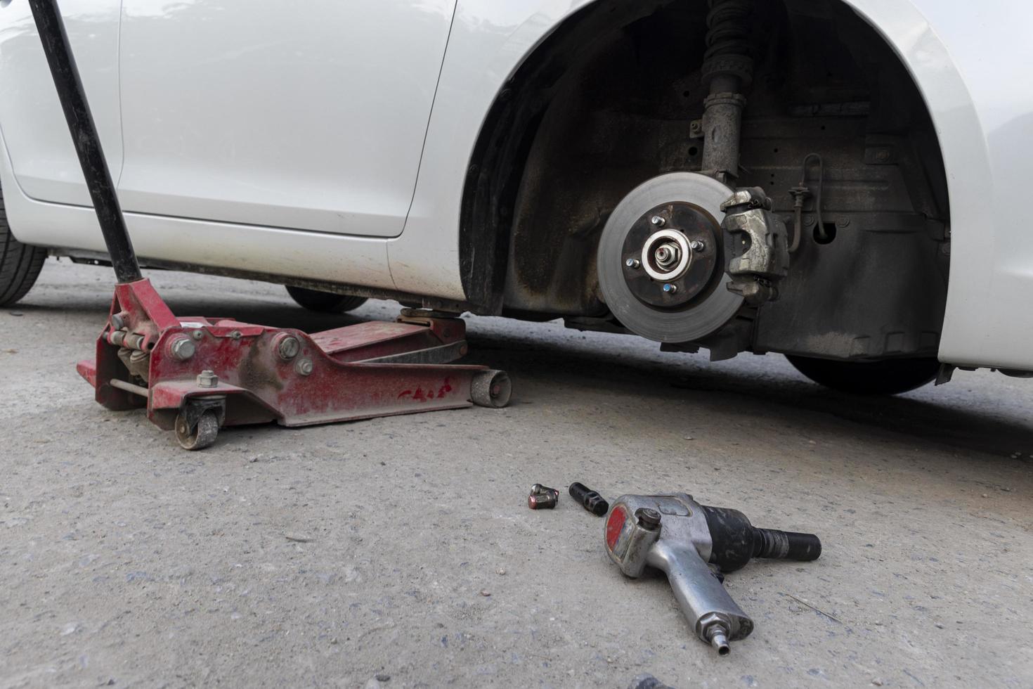 White cars change wheels using a lifting jack. photo