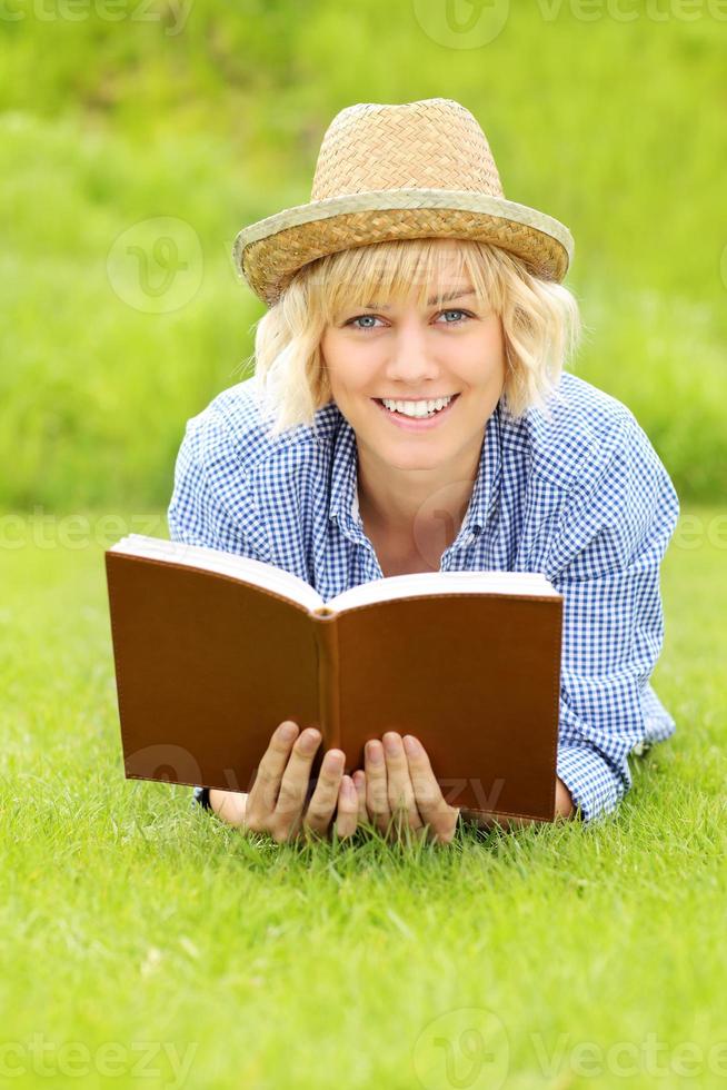 mujer joven en una hierba con un libro foto