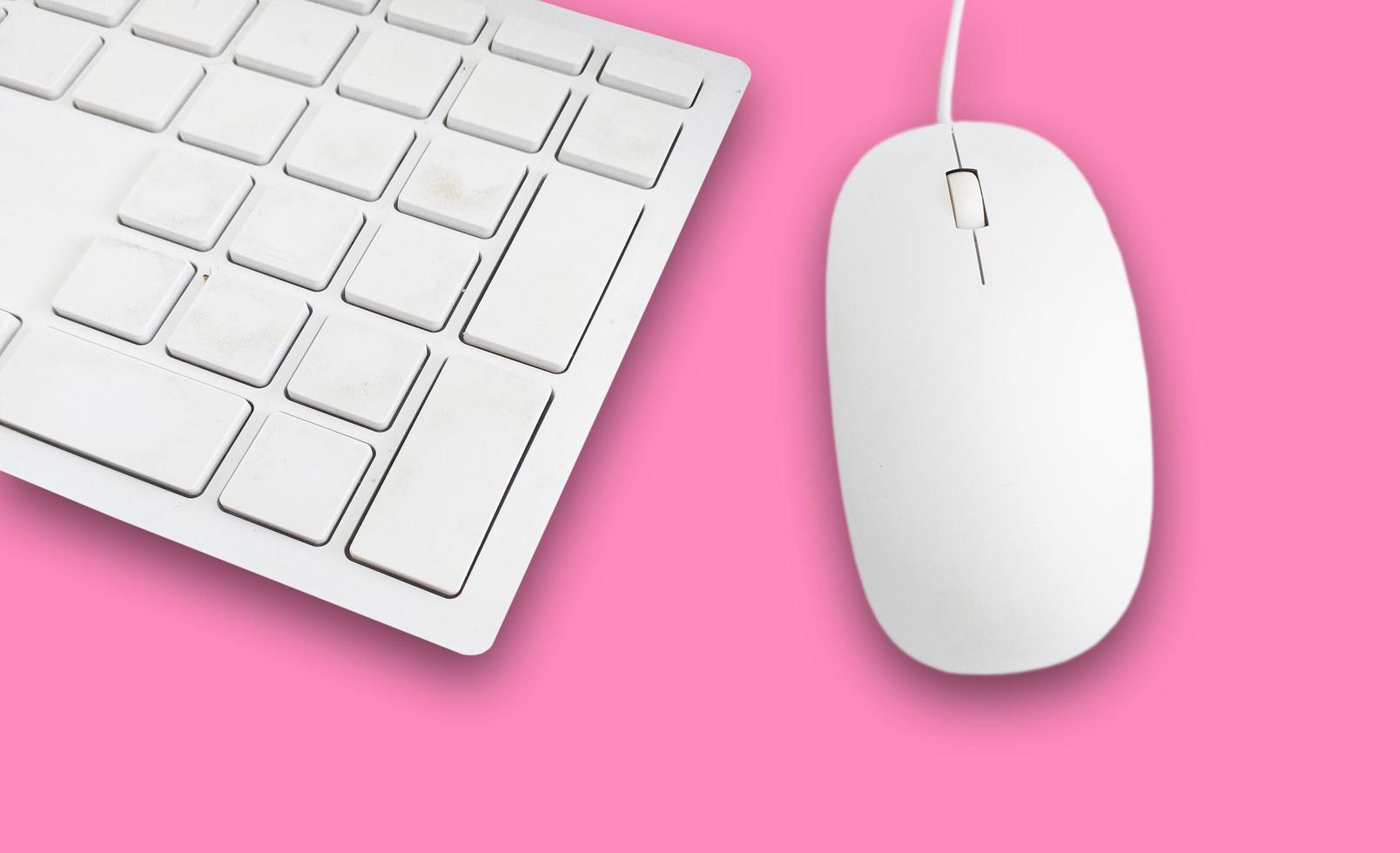 teclado y mouse sobre un fondo rosa foto