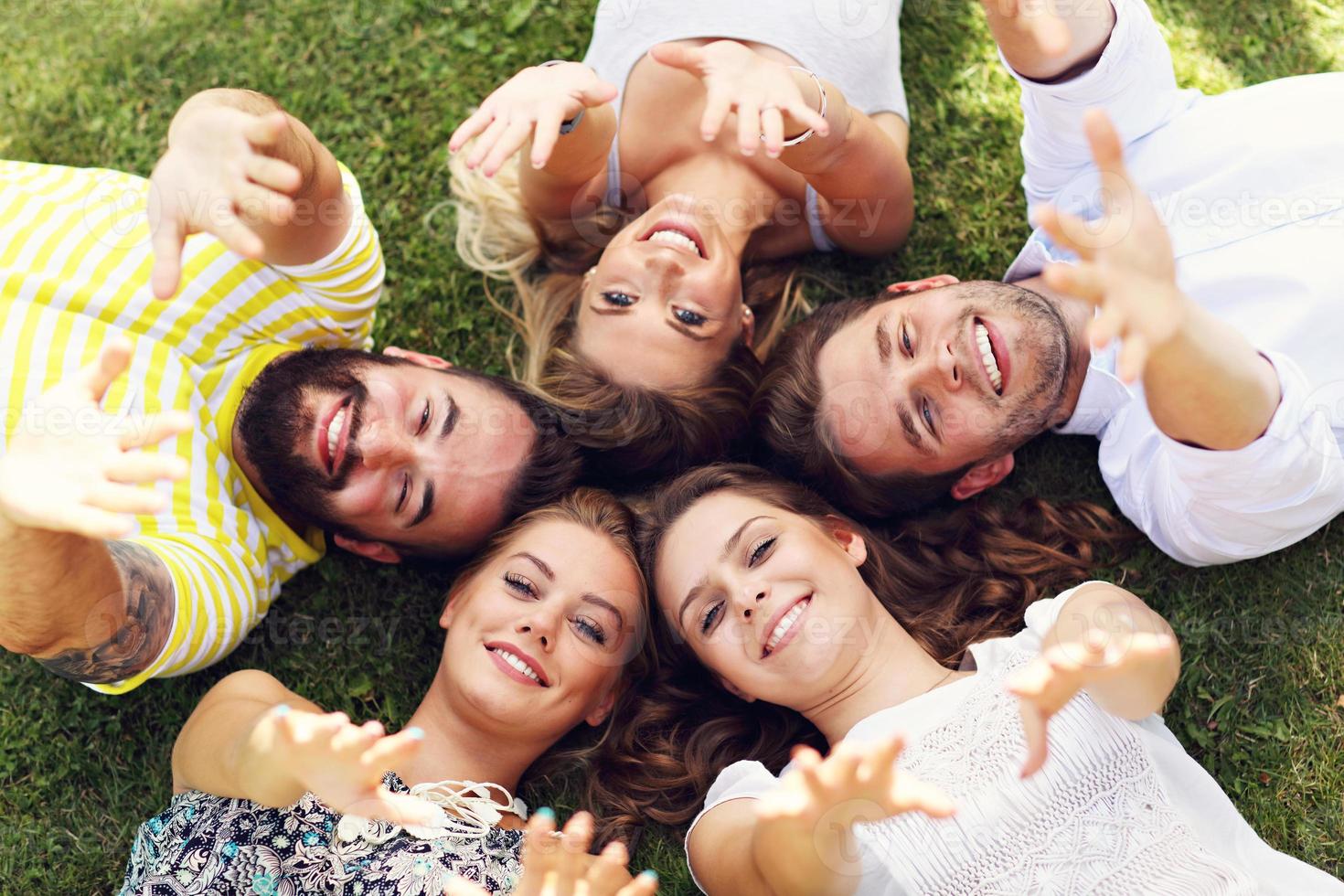 grupo de amigos divirtiéndose juntos en el césped foto