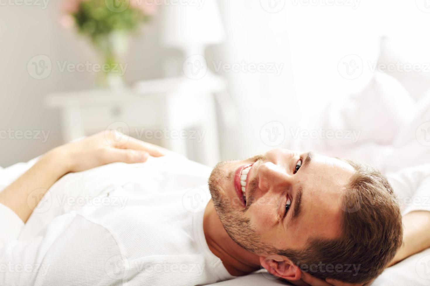 Handsome man lying in bed photo