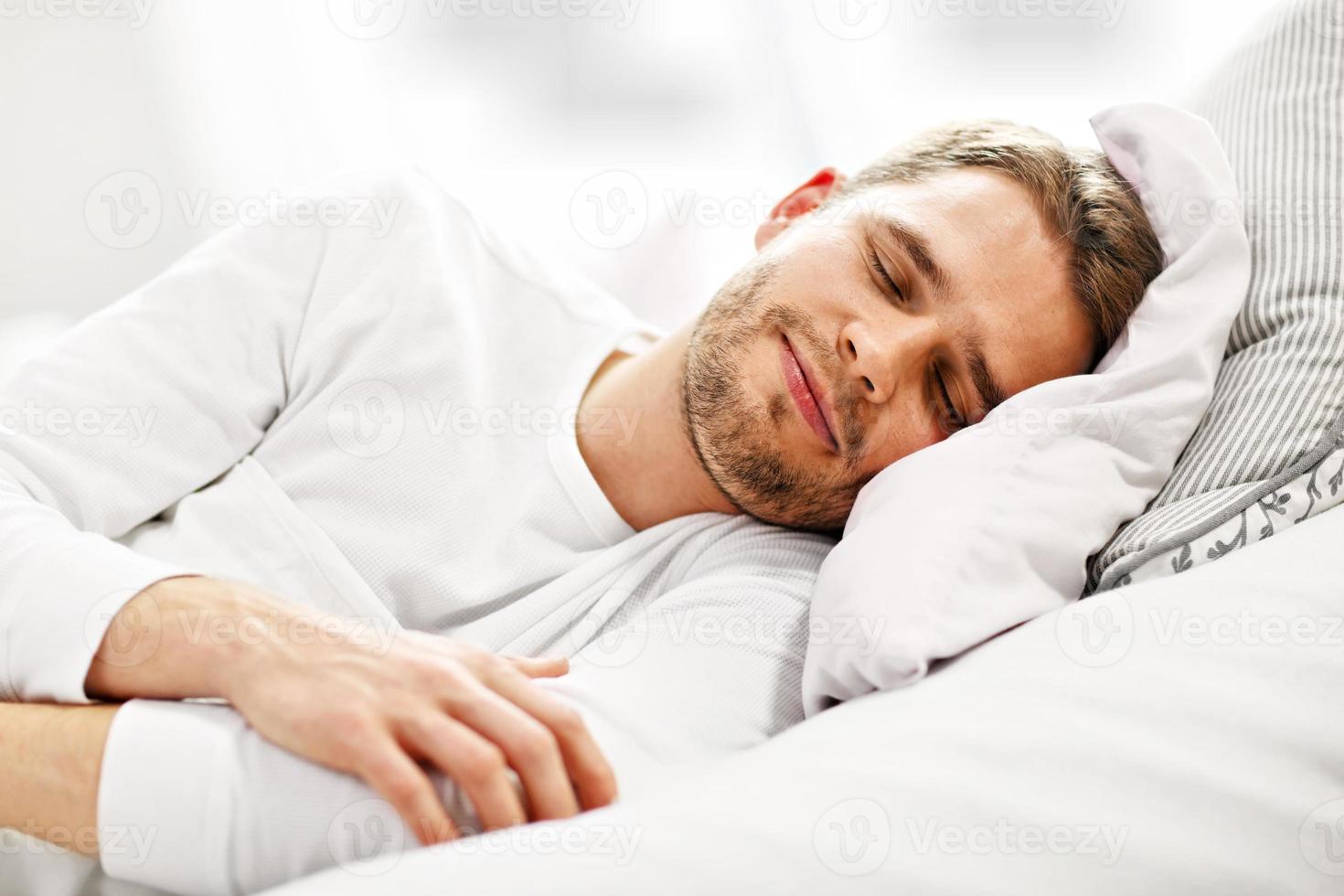 Young man sleeping in bed photo
