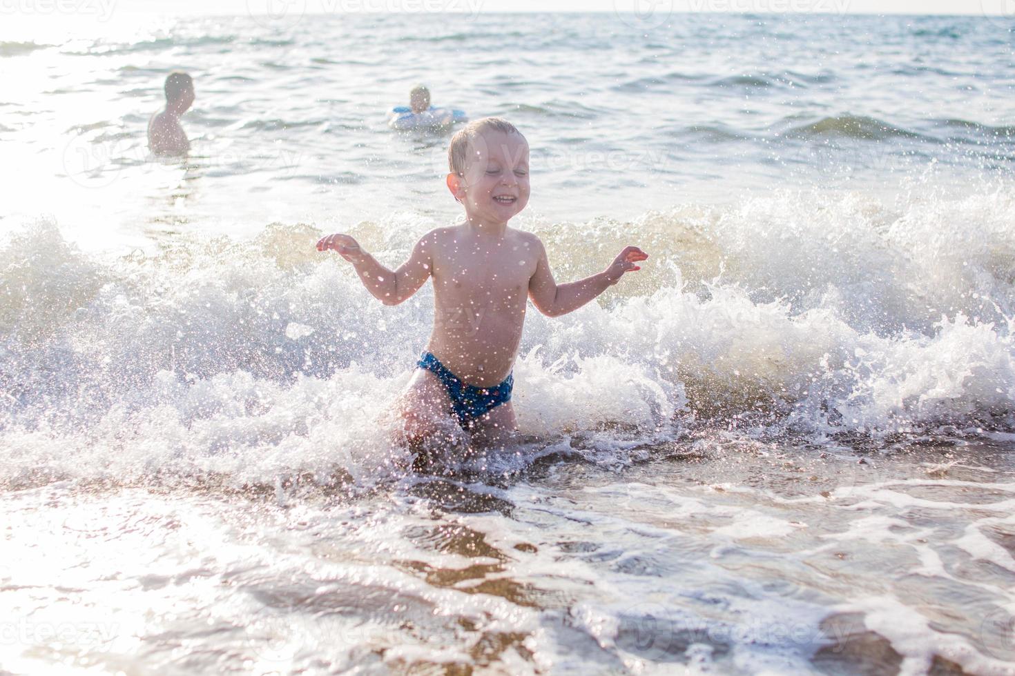 a little boy having fun in the sea on the waves photo