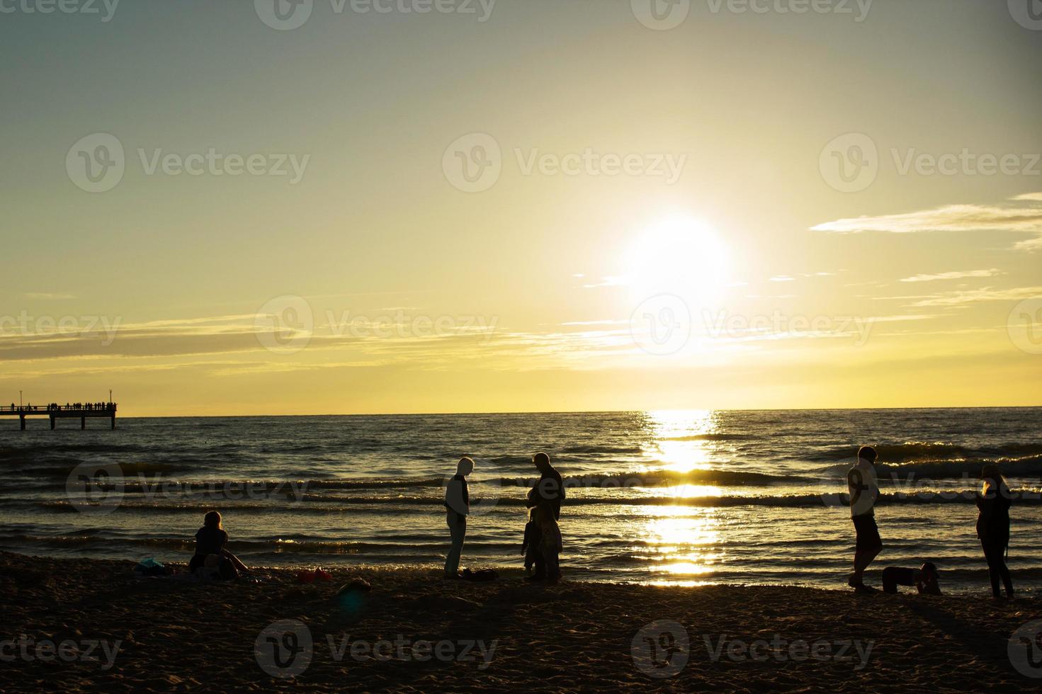 silhouettes of people on the beach photo