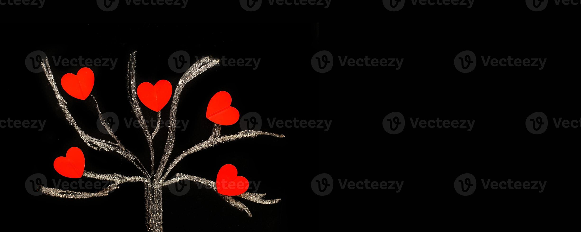 chalk drawing tree on a black chalkboard with red hearts on a tree photo
