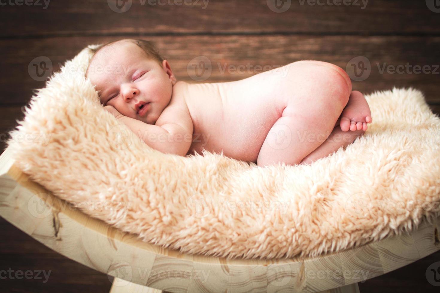 bebé recién nacido durmiendo sobre un fondo de madera foto