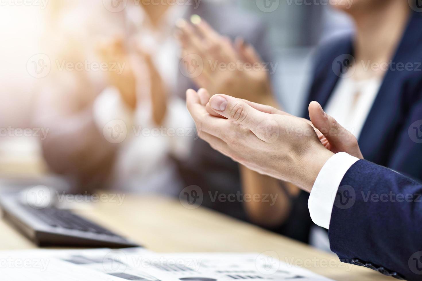 Midsection of businesspeople clapping hands at conference photo