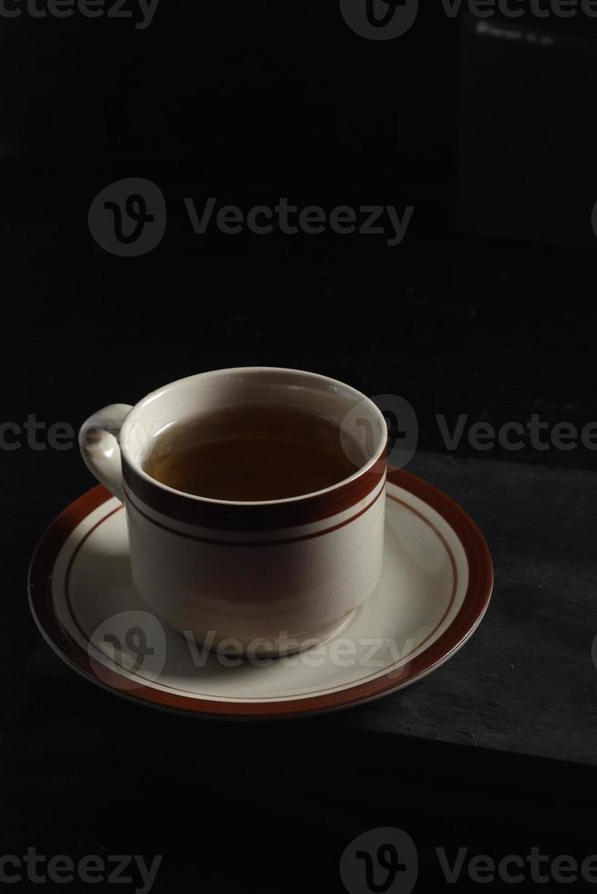 taza de té aislado en un fondo negro foto