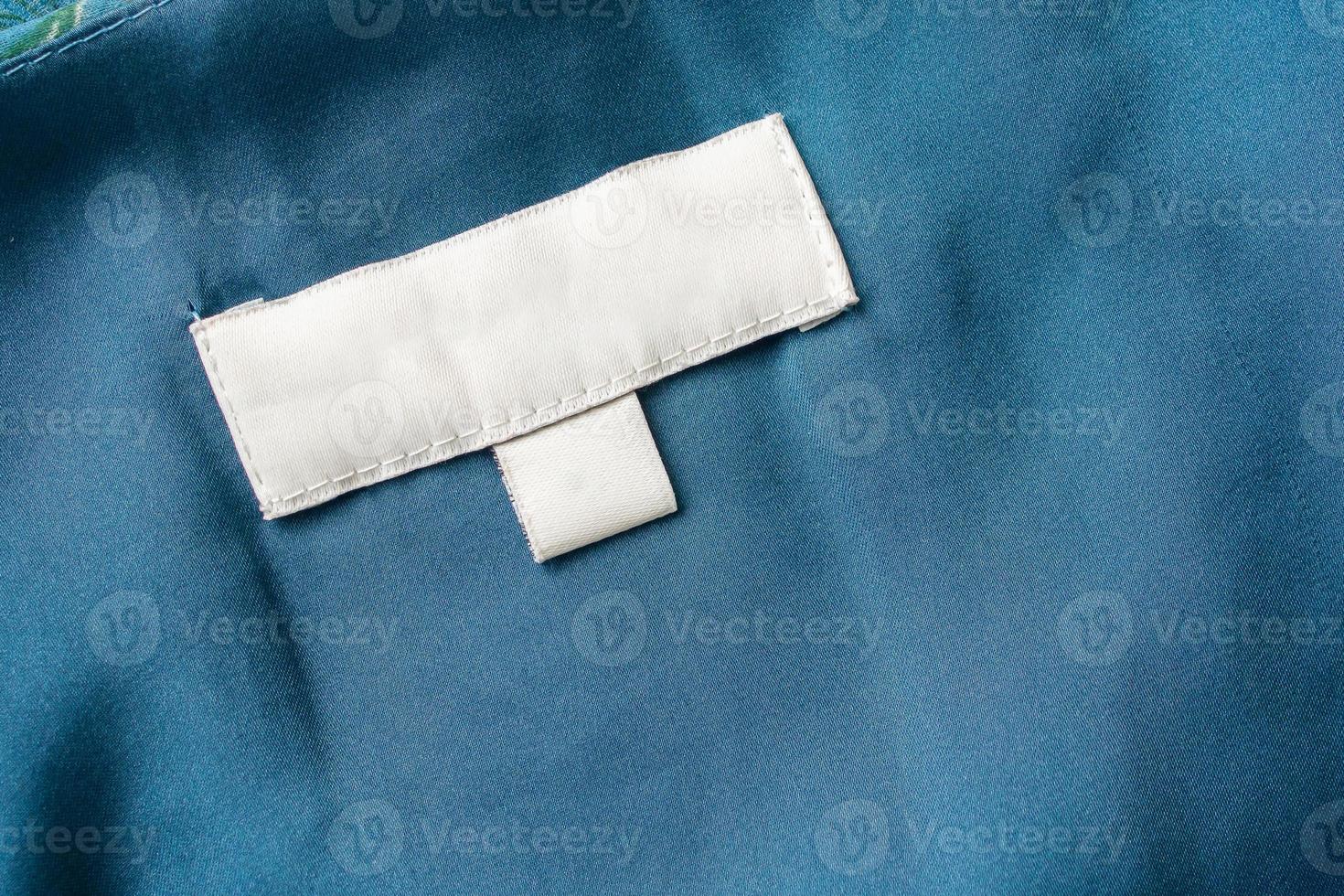 White blank laundry care clothes label on fabric background photo