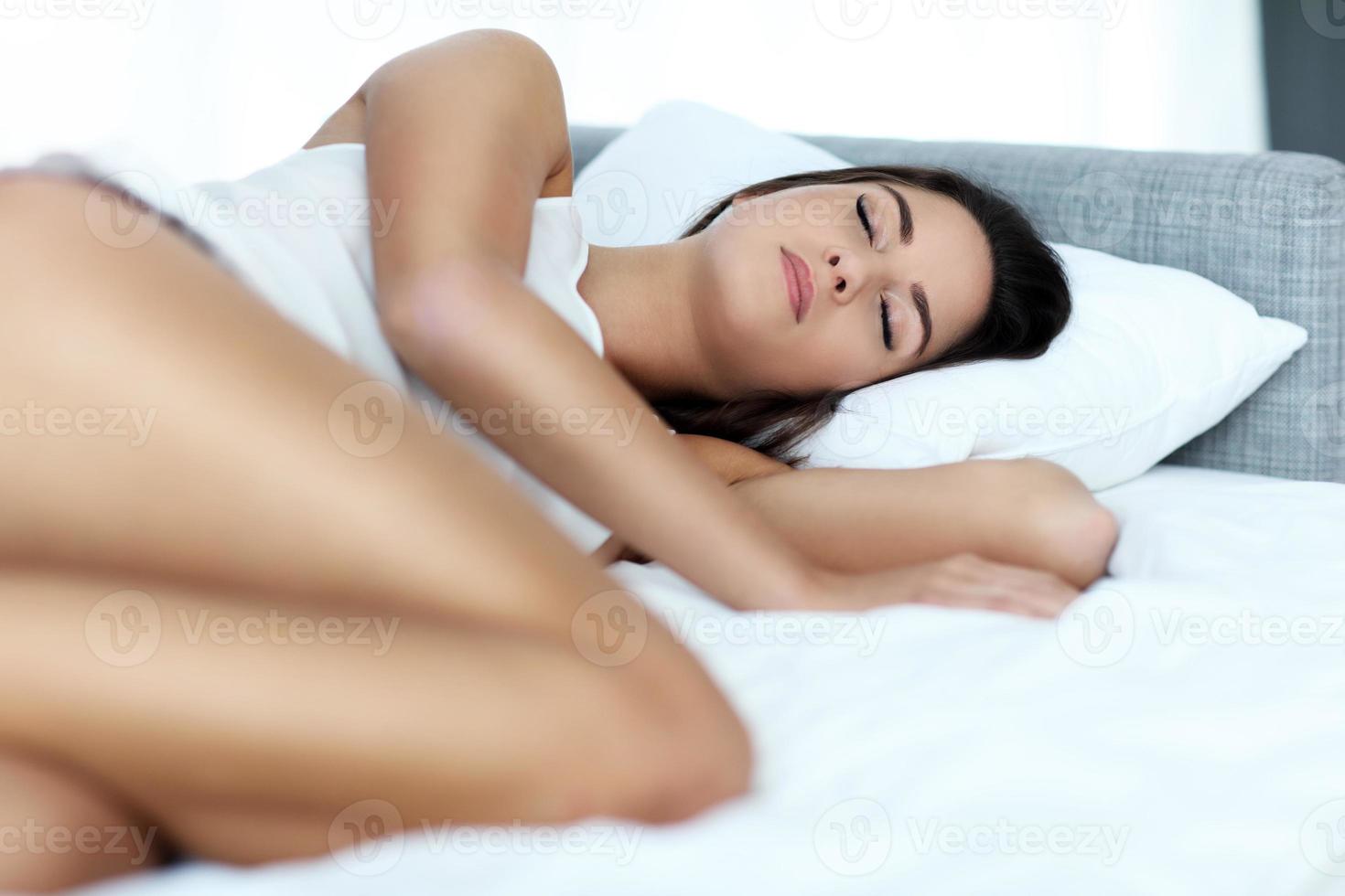 hermosa mujer joven durmiendo en la cama foto