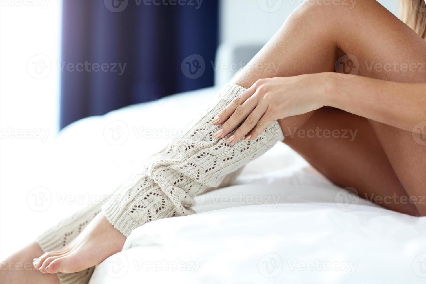 Young woman putting on warmers in bed 15765964 Stock Photo at Vecteezy