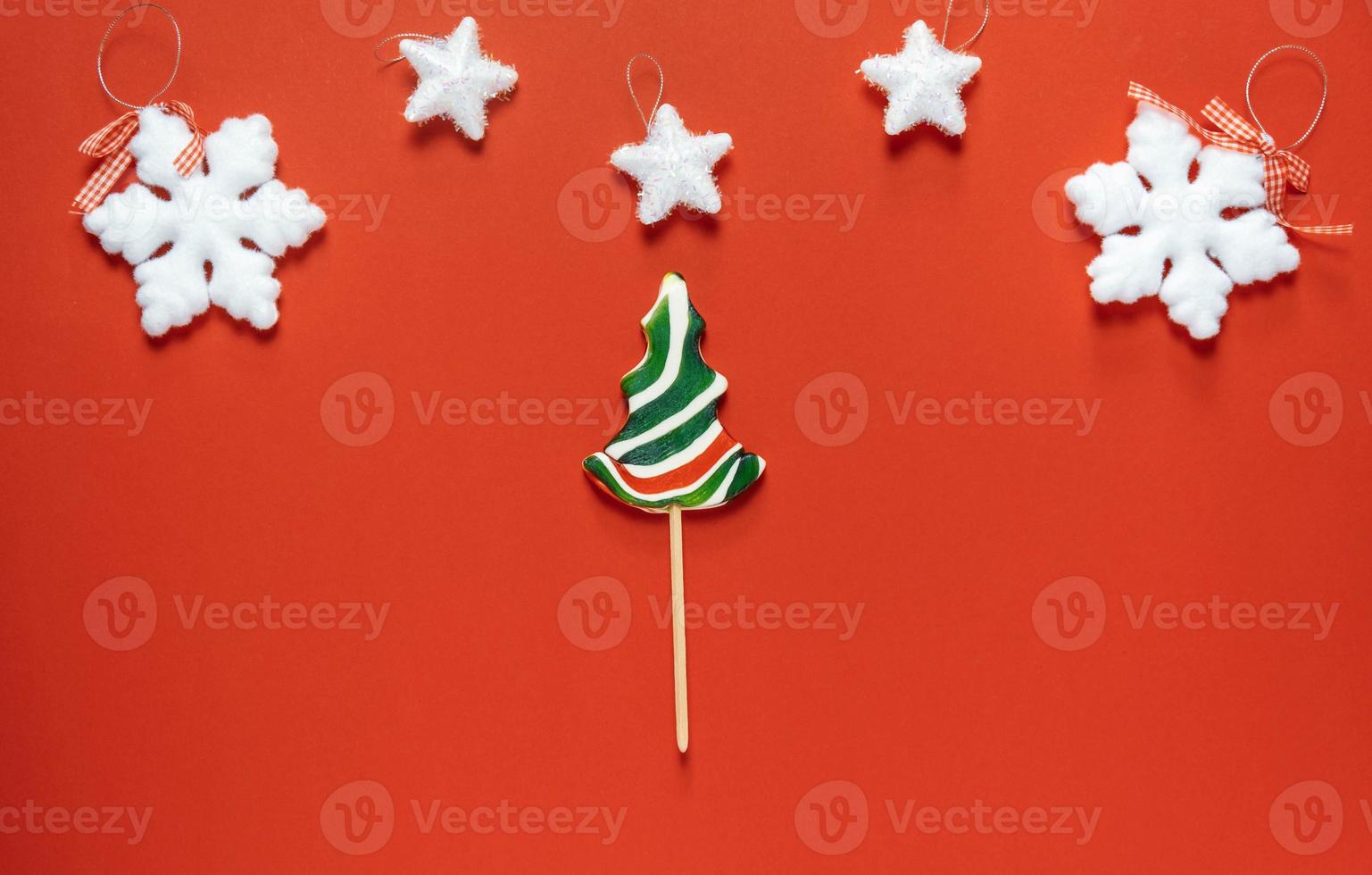 Christmas or winter composition. Frame made of snowflakes and candy trees on a red background. Christmas, winter, new year concept. Flat lay photo