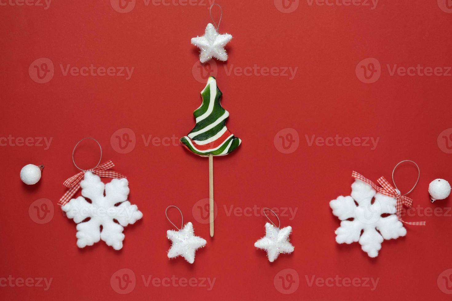 Christmas or winter composition. Frame made of snowflakes and candy trees on a red background. Christmas, winter, new year concept. Flat lay photo