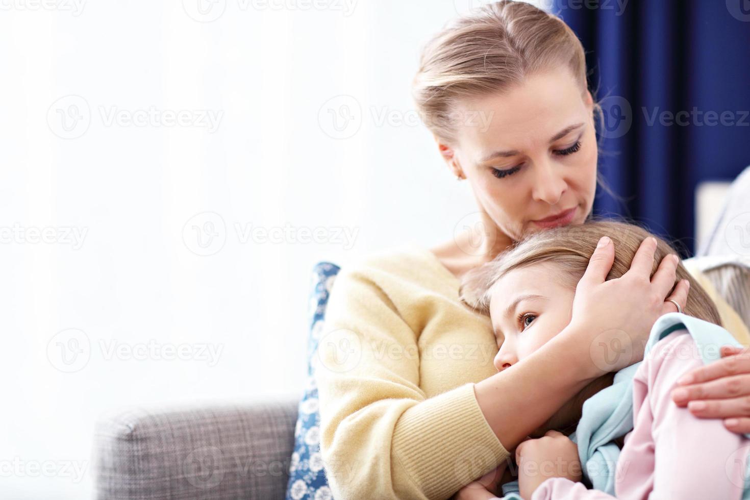 Sad little girl and her mom at home photo