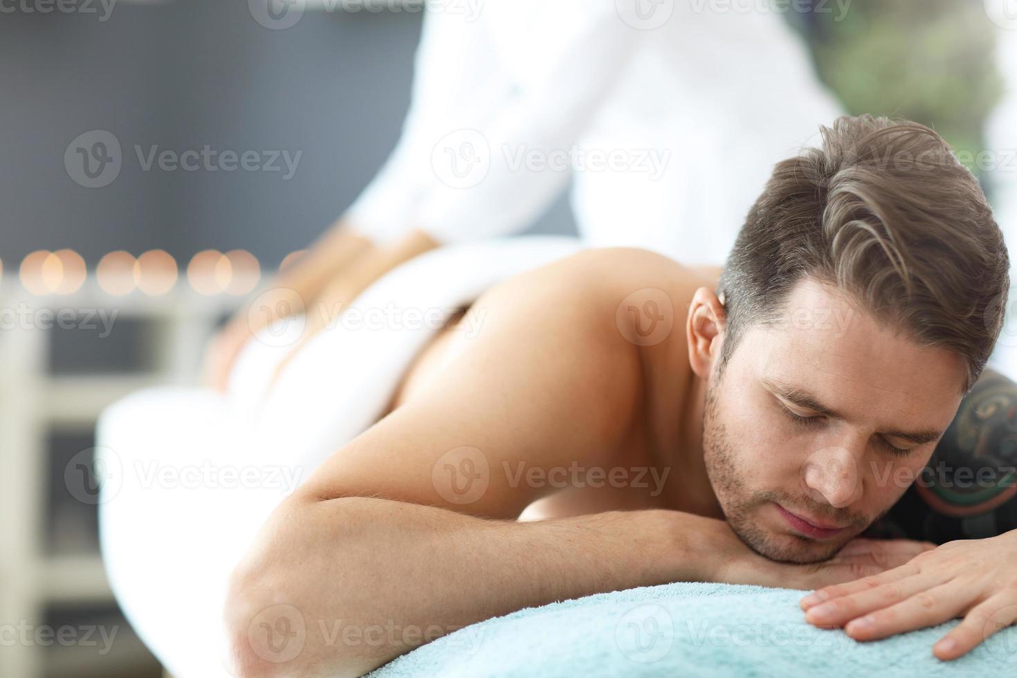 Handsome man having massage in spa salon photo