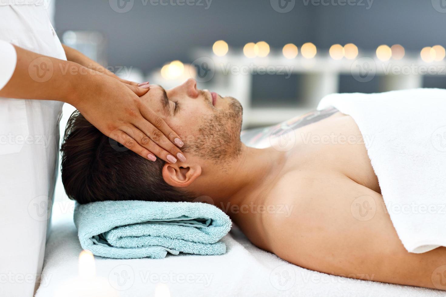 Handsome man having massage in spa salon photo