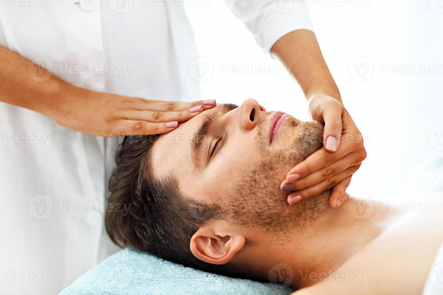 Handsome man having massage in spa salon photo