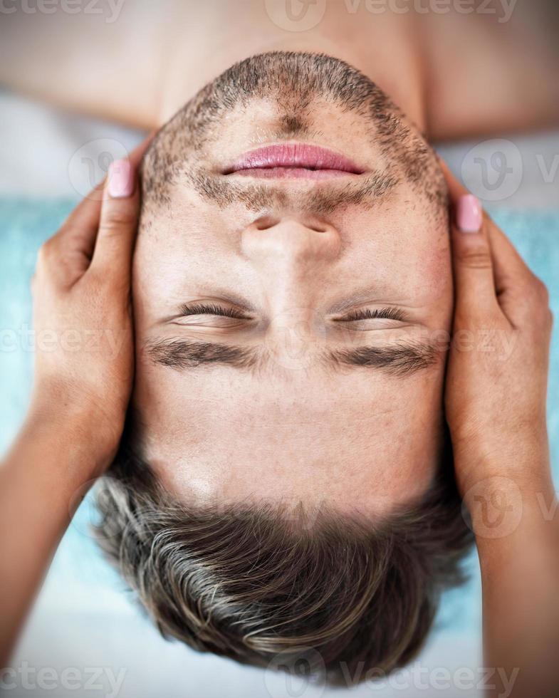 Handsome man having massage in spa salon photo