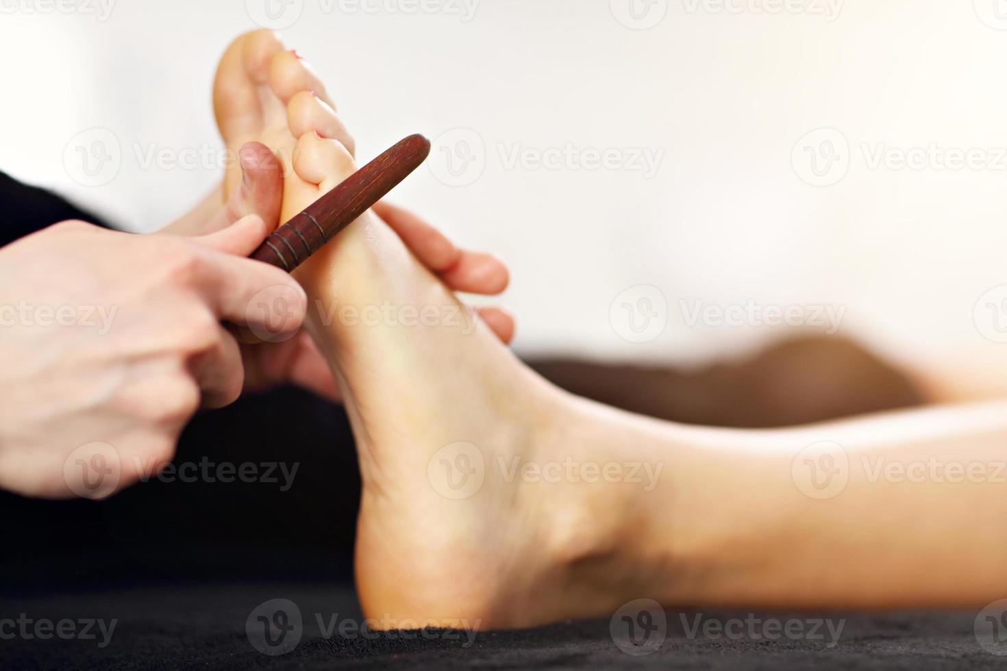 Woman receiving a thai foot massage at the health spa photo