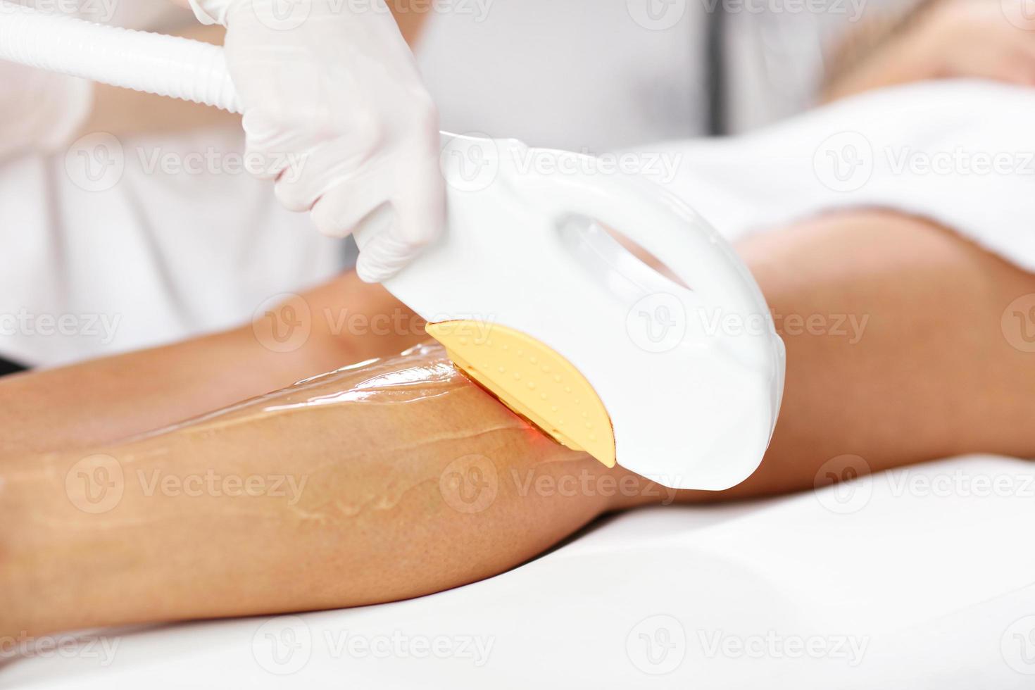 Beautician Giving Depilation Laser Treatment To Woman On Legs photo