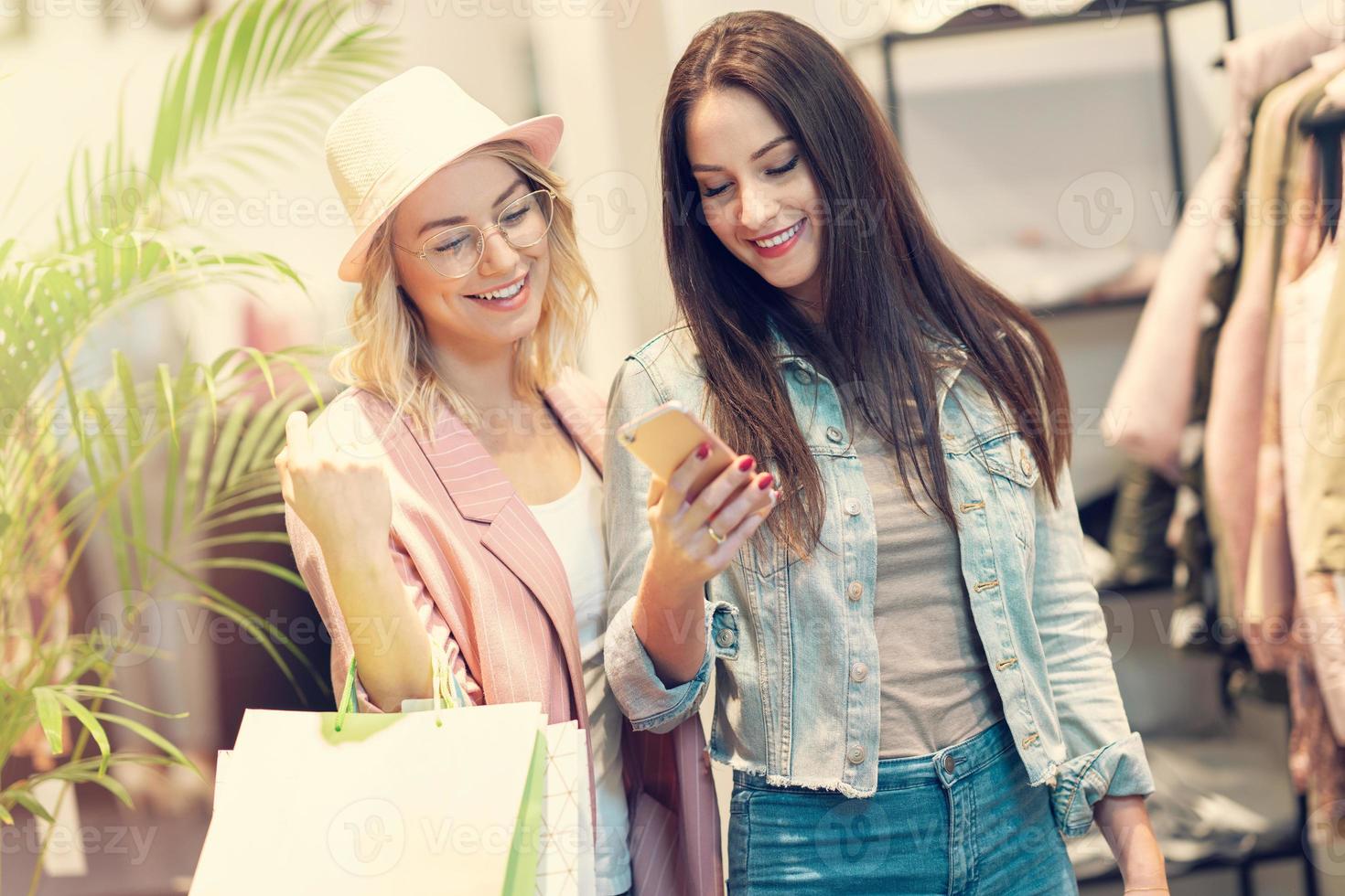 Girl friends shopping for clothes in store photo