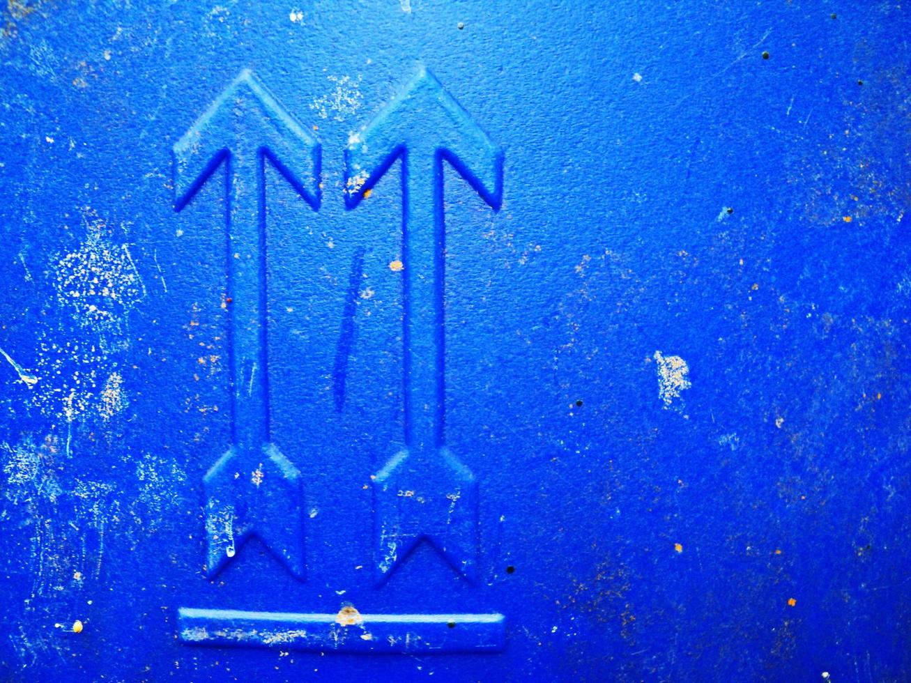 Abstract grunge write arrow pointing up, blue tank backdrop with spots cracks. Dot rough surface nameplate. photo