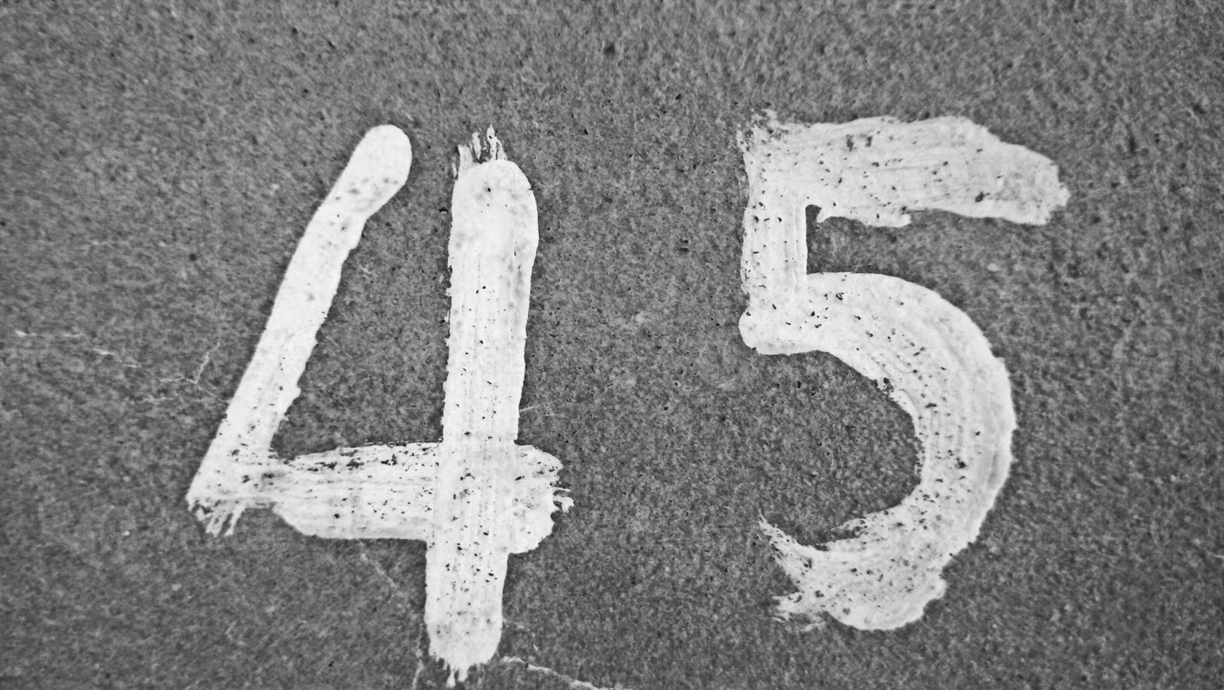 45 white number, with grey wallpaper cement for texture background abstract concept. photo