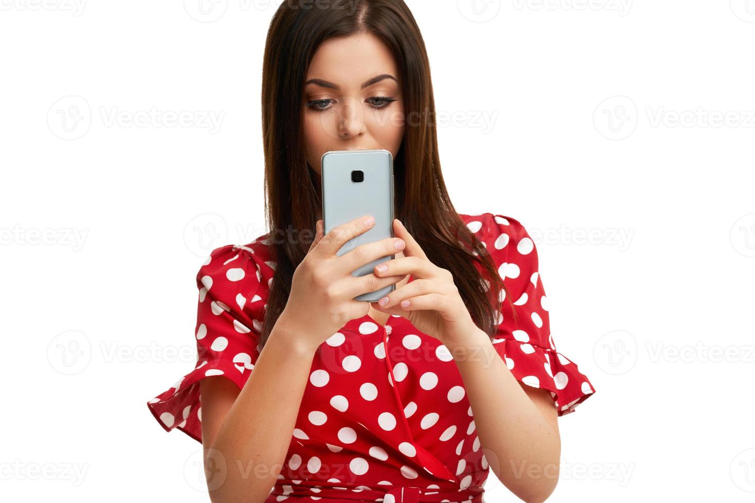 Caucasian brunette woman using smartphone isolated over white background photo