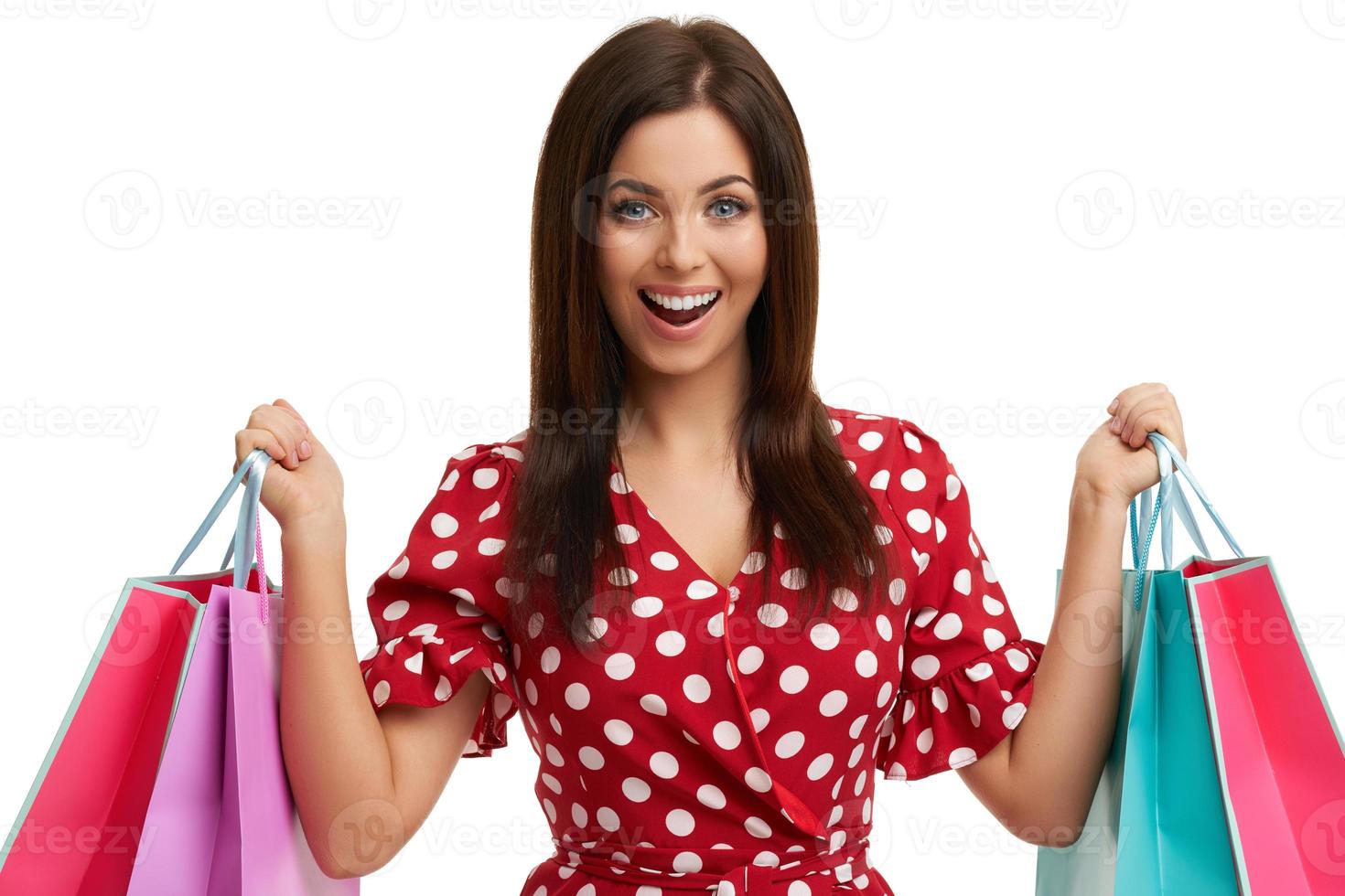 Caucasian brunette woman holding shopping bags isolated over white background photo