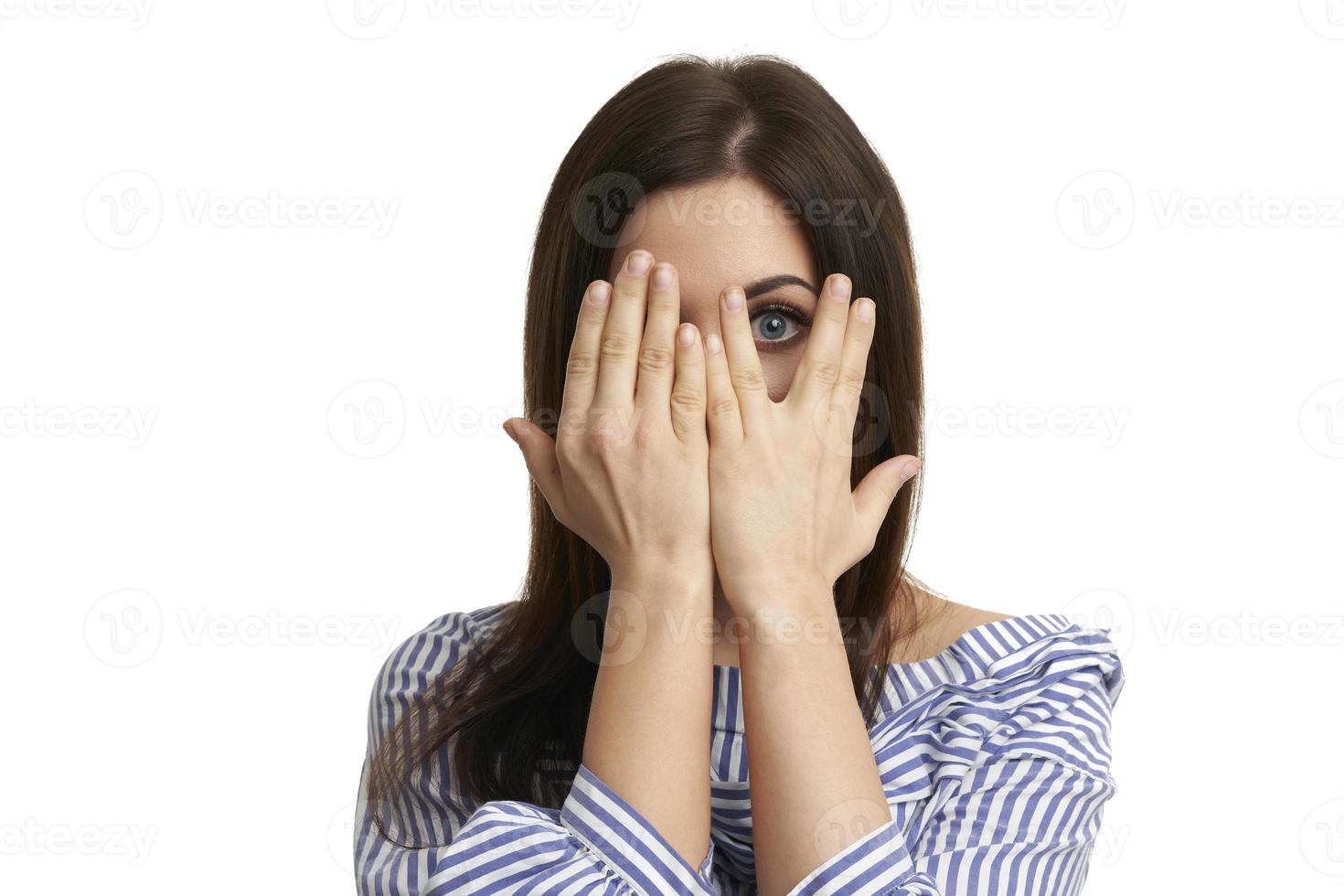 Shocked girl covers her face with hands isolated on white photo