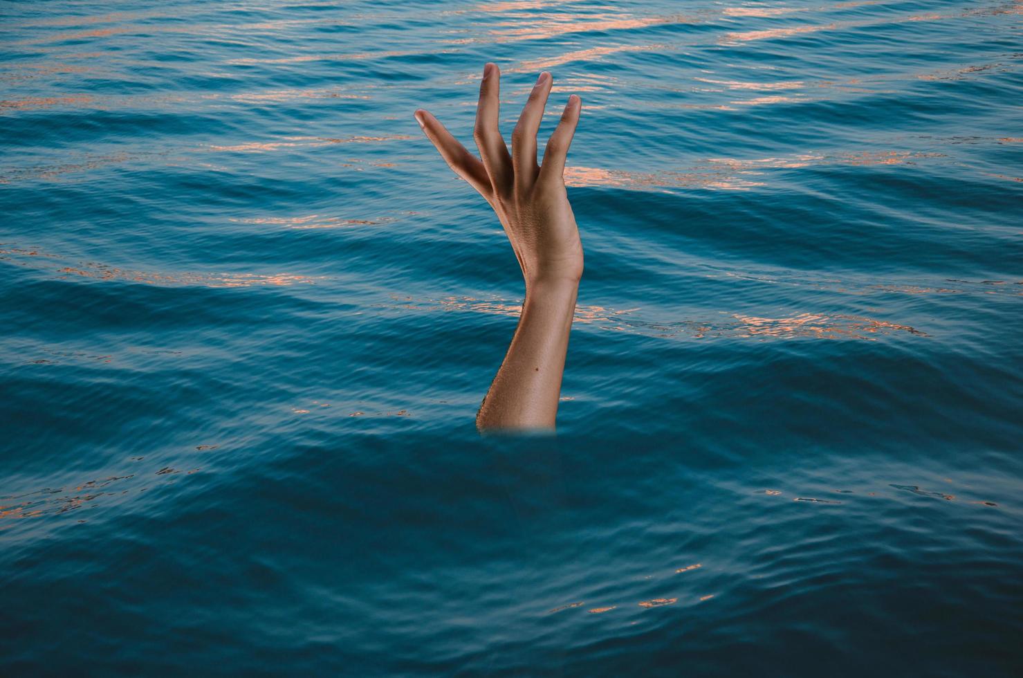 Drowning victims, Hand of drowning man needing help. Failure and rescue concept. photo