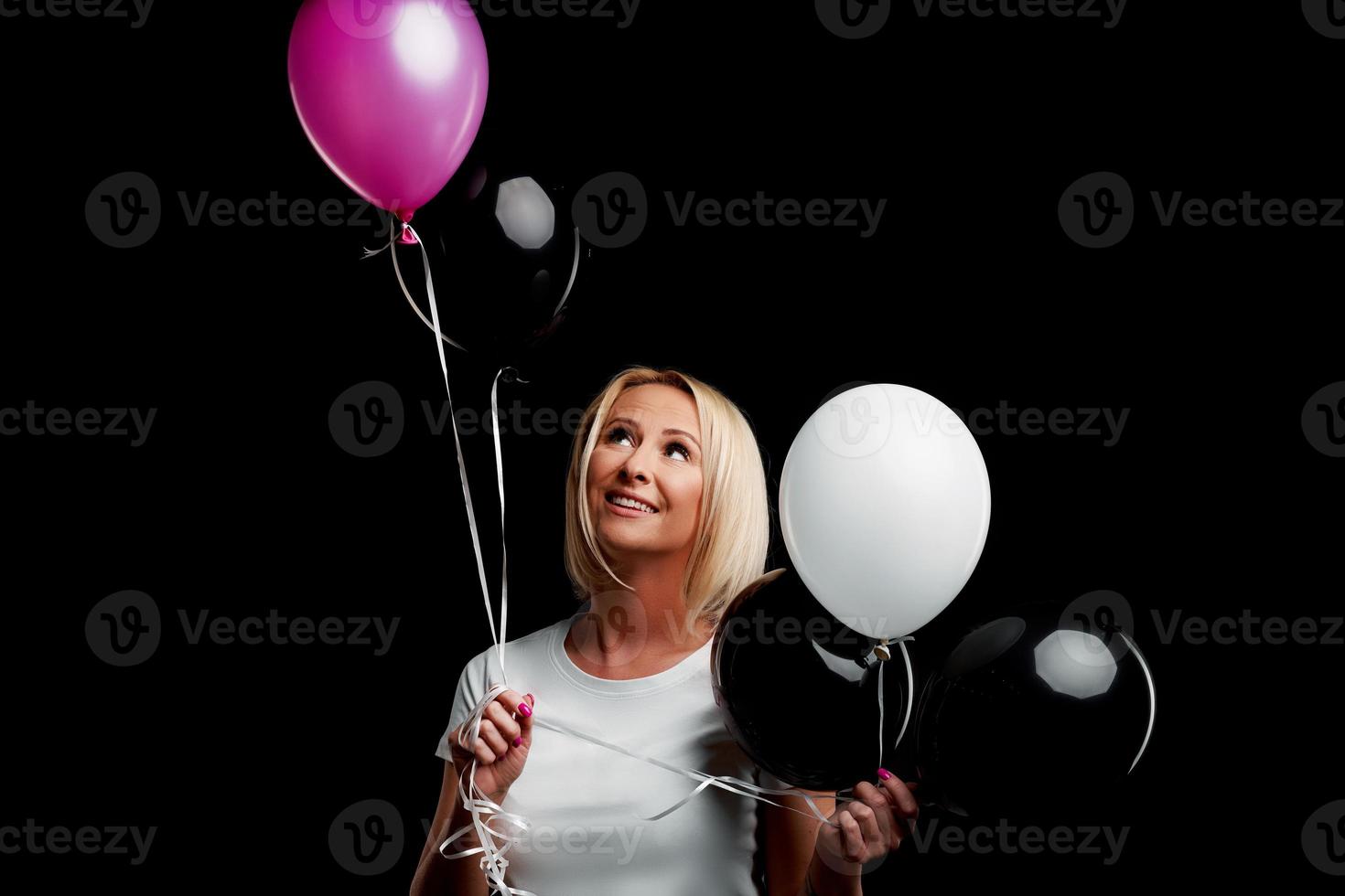 Happy adult woman dancing over black background photo