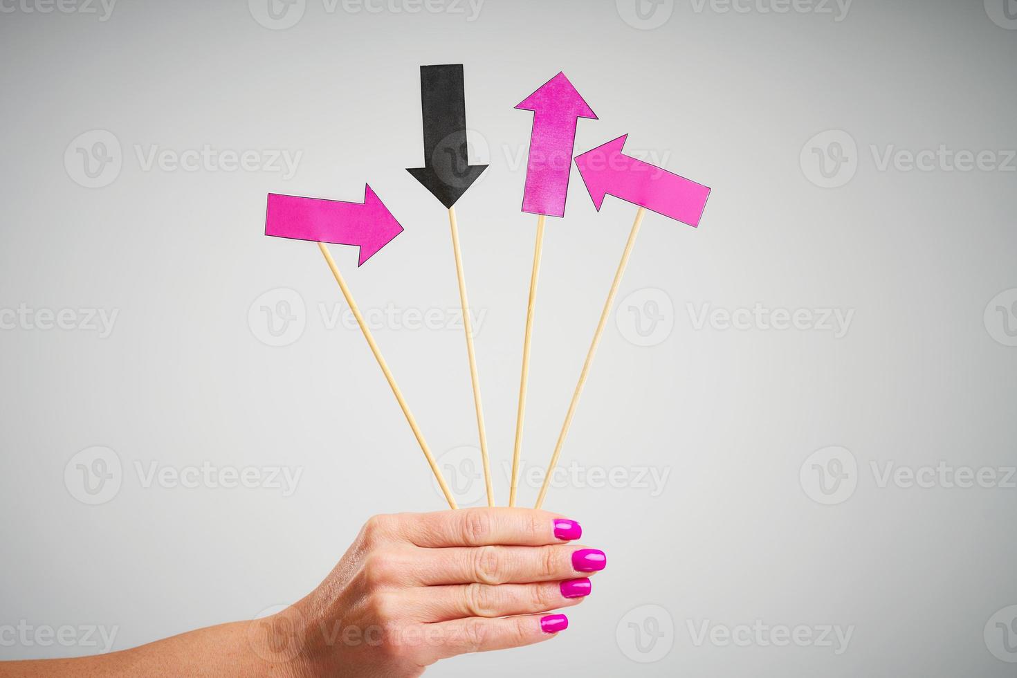Female hand holding arrows over grey background photo