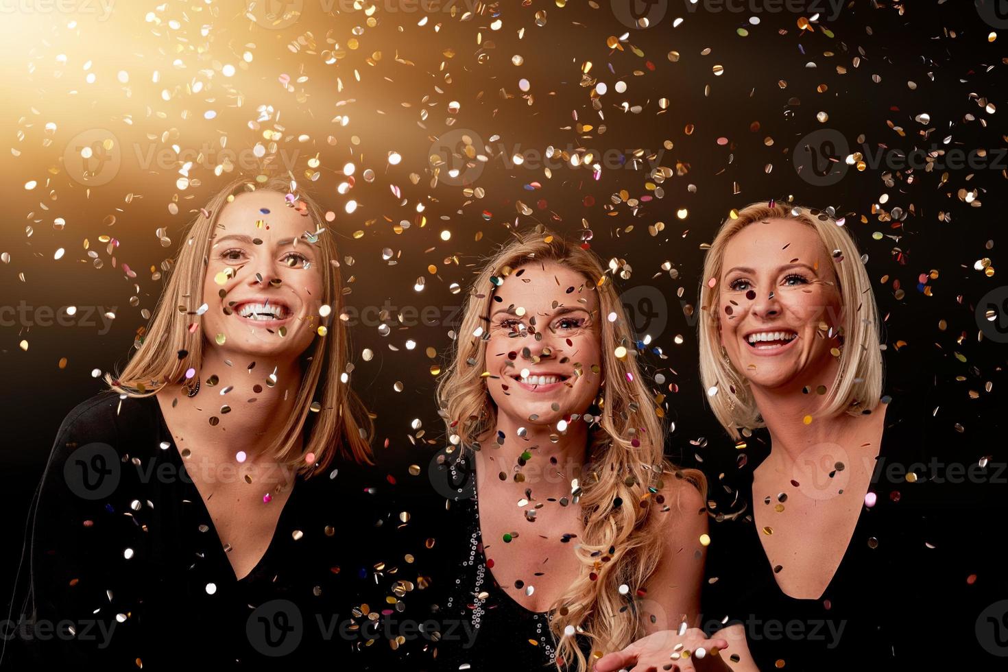 Group of friends partying in a nightclub and toasting drinks photo