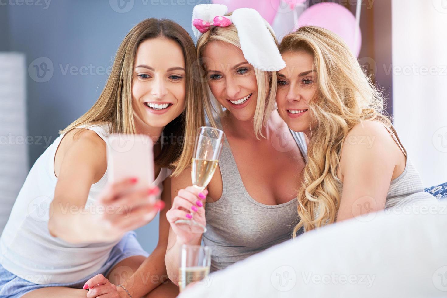 Picture presenting happy group of friends using smartphone photo