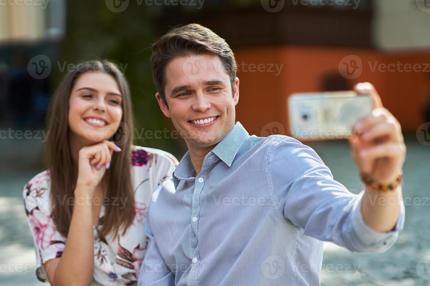 Young couple dating in the park and using smartphones photo