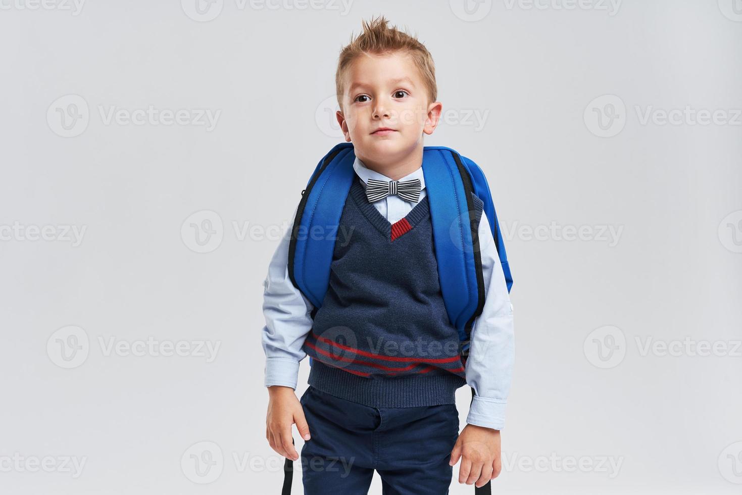 Portrait of a boy ready to school isolated on white photo