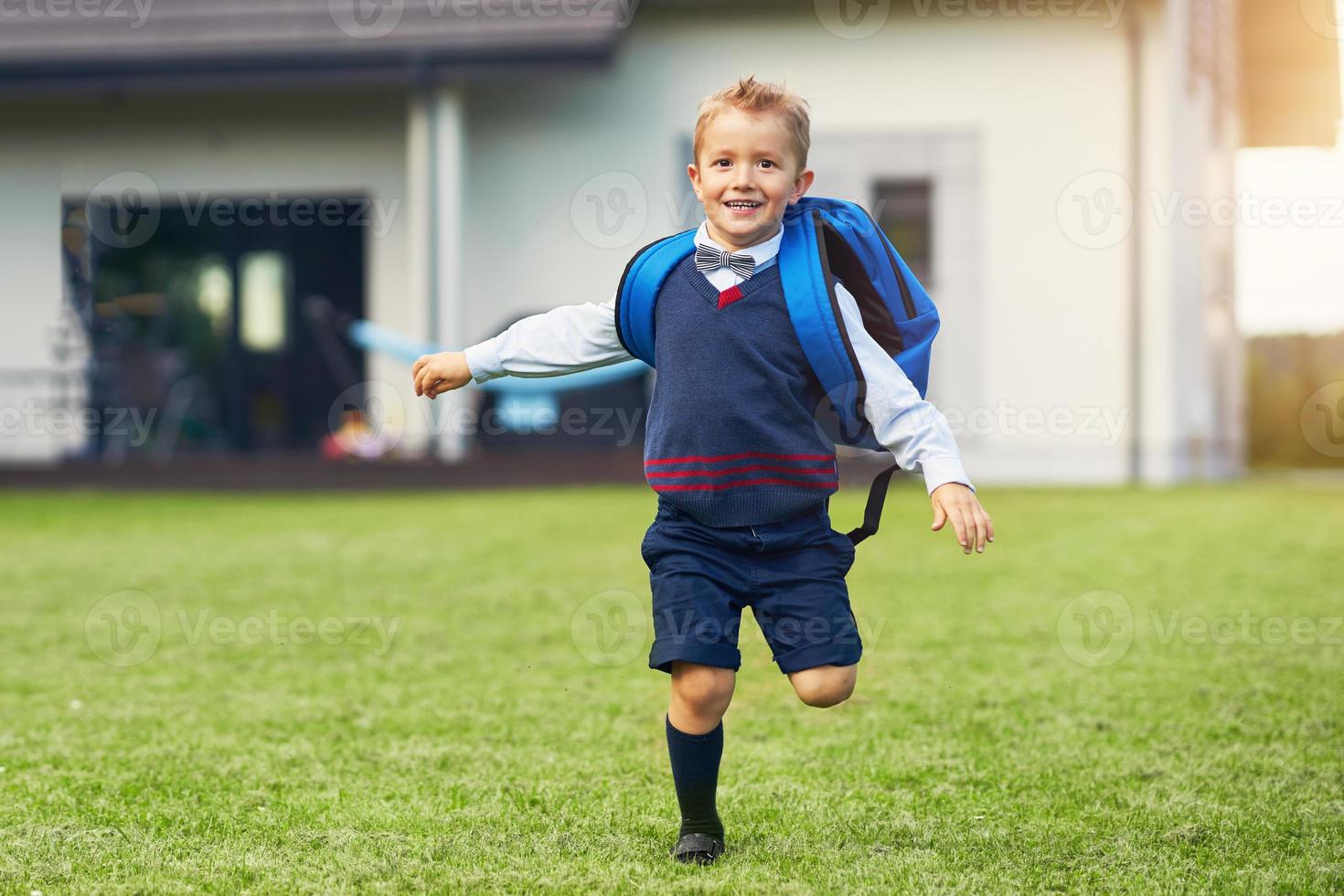 Happy little preschool kid boy with backpack posing outdoors photo