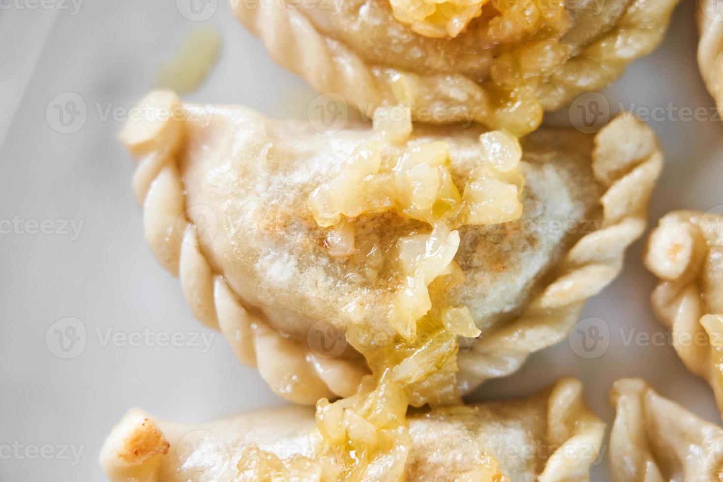Fried dumplings stuffed with meat carmelized onion on white plate photo