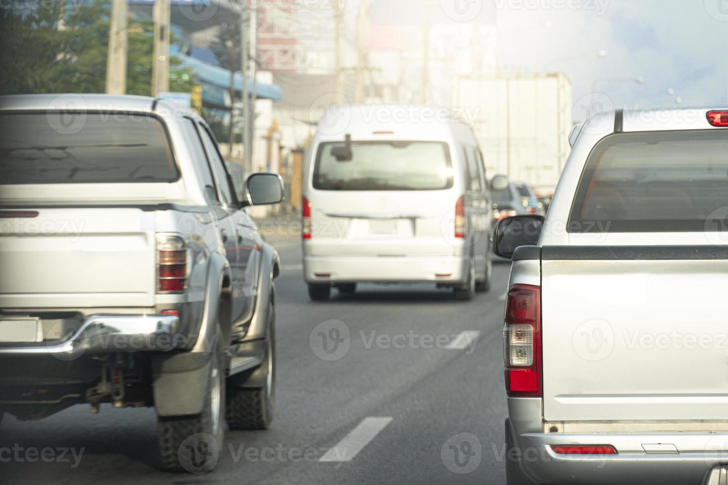 Rear side of pickup silver color driving on the asphalt road. Drive in the business time or trip to travel. Environment in the city. photo