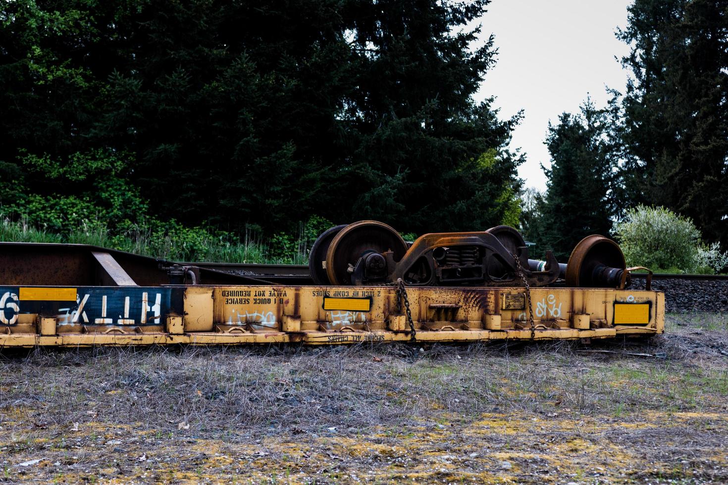 vagón de ferrocarril descarrilado volcado junto a las vías foto