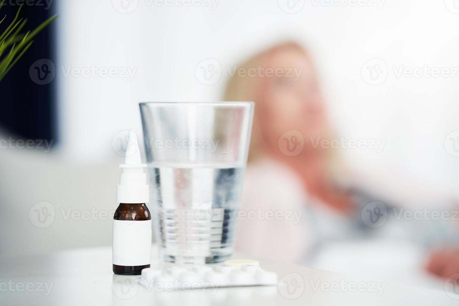 Adult woman feeling unewll and taking tablets at home photo