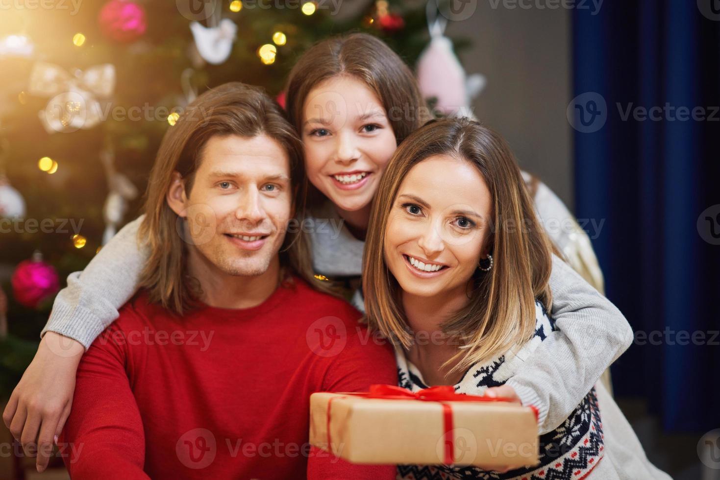 Beautiful family with presents over Christmas tree photo