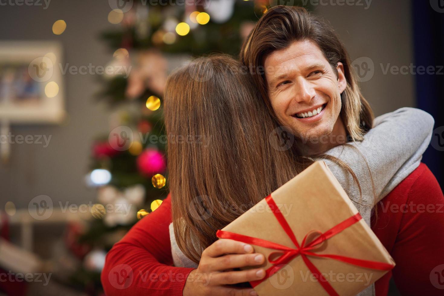 Daughter and father with present over Christmas tree photo