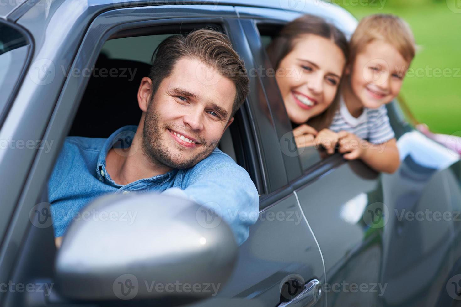 familia sentada en el auto mirando por las ventanas foto