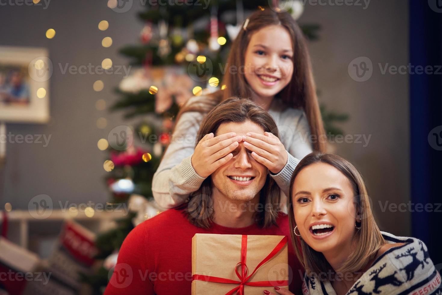 Beautiful family with presents over Christmas tree photo