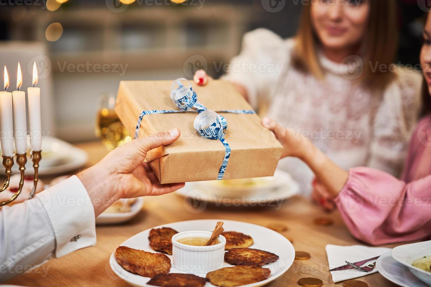 Hanukkah dinner. Family gathered around the table with traditional dishes photo