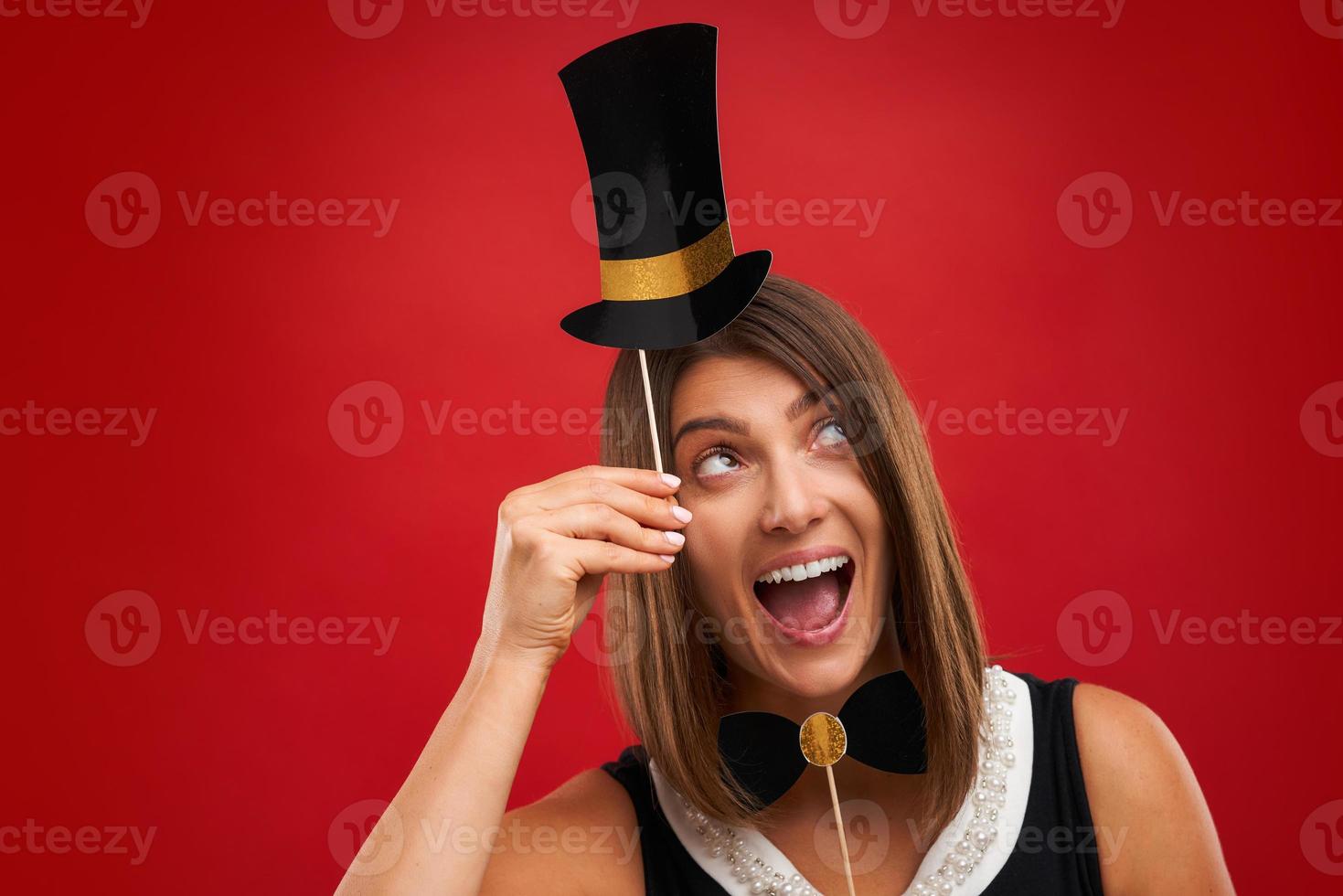 Attractive brunette woman posing with New Year photo gadgets over red background